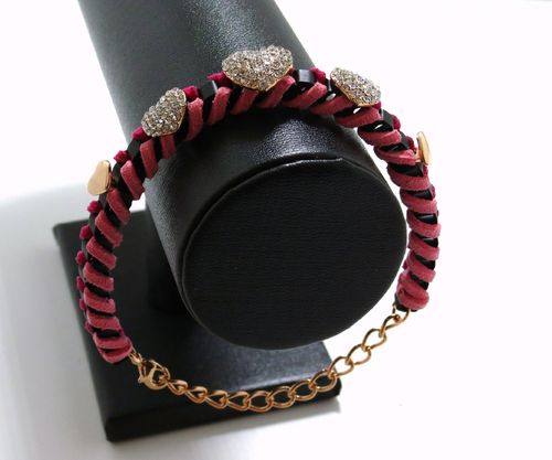Modieuse armband van roze suede met goudkleurige studs en strass hartjes  ± 17cm lang  plus verlengk